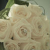 Simple bouquet of white roses with silver jewels, surrounded by green accents